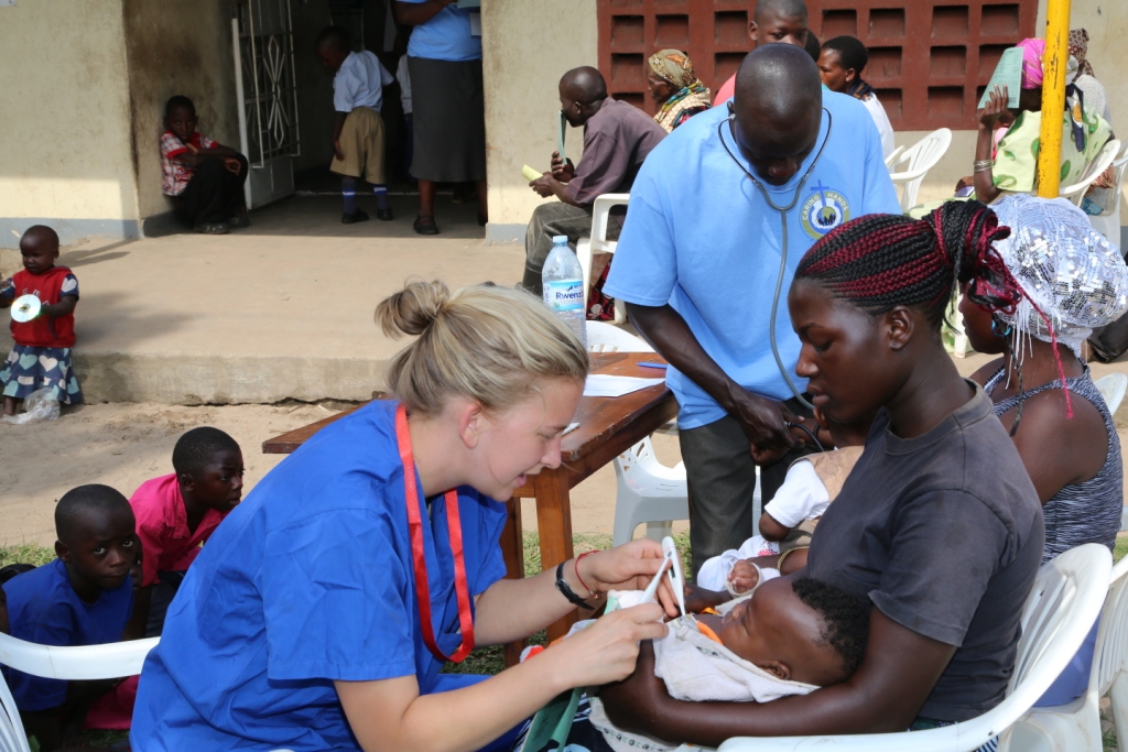 A VOLUNTEER ATTENDING TO A PATIENT